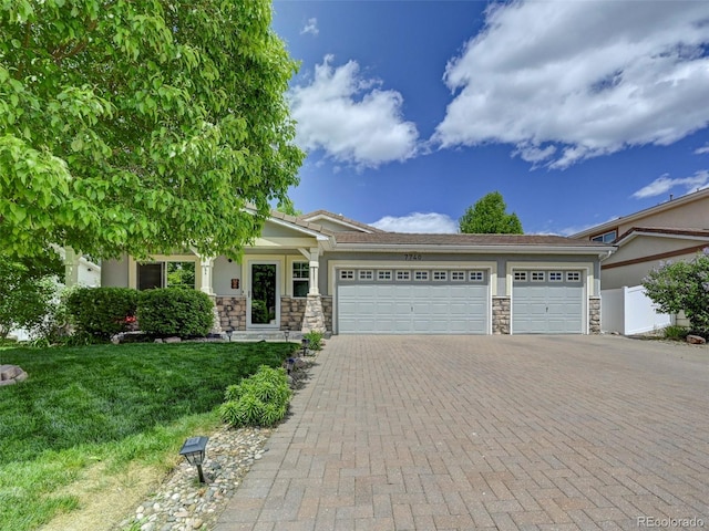 view of front of property with stone siding, a garage, decorative driveway, and stucco siding