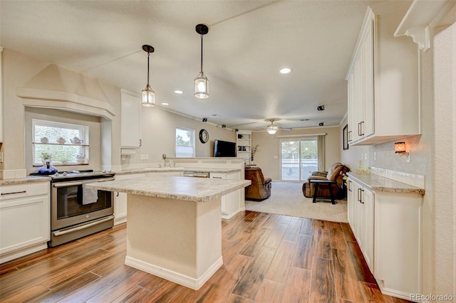 kitchen featuring appliances with stainless steel finishes, open floor plan, wood finished floors, white cabinets, and recessed lighting