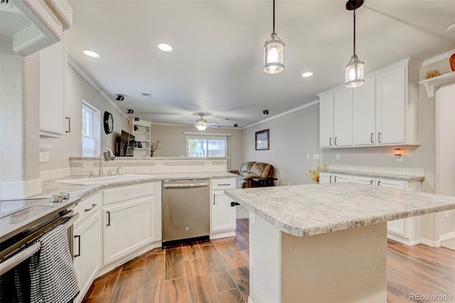kitchen featuring appliances with stainless steel finishes, a sink, crown molding, a peninsula, and a ceiling fan