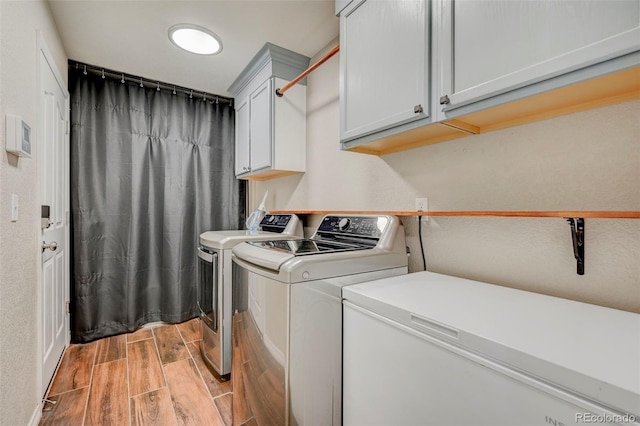 washroom featuring wood finish floors and washing machine and clothes dryer
