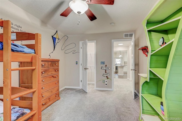 carpeted bedroom featuring a textured ceiling and baseboards