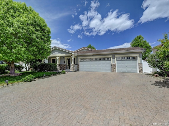 view of front of property with stone siding, decorative driveway, an attached garage, a porch, and stucco siding