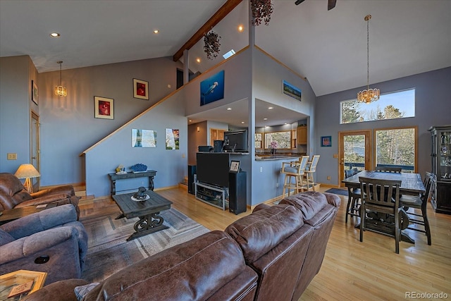 11222 Conifer Mountain Rd, Conifer, CO 80433 - living room featuring light wood finished floors, high vaulted ceiling, and a chandelier