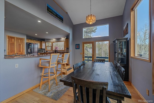 11222 Conifer Mountain Rd, Conifer, CO 80433 - dining space with a chandelier, light wood-style flooring, and high vaulted ceiling