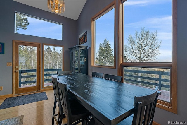 11222 Conifer Mountain Rd, Conifer, CO 80433 - dining area featuring a chandelier, wood finished floors, and lofted ceiling