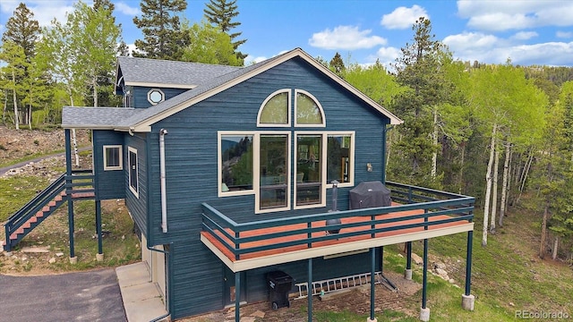 11222 Conifer Mountain Rd, Conifer, CO 80433 - rear view of house with a deck, stairway, and a shingled roof