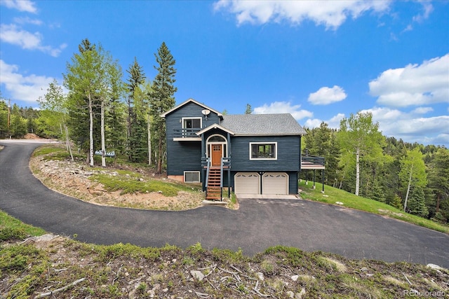 11222 Conifer Mountain Rd, Conifer, CO 80433 - view of front of home featuring a garage, driveway, and a wooded view