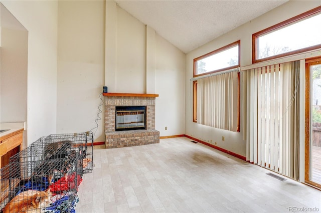 5185 E Weaver Dr, Centennial, CO 80121 - unfurnished living room featuring high vaulted ceiling, plenty of natural light, wood finished floors, and a fireplace