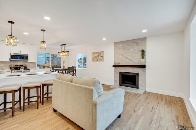 living room featuring a fireplace and light wood-type flooring