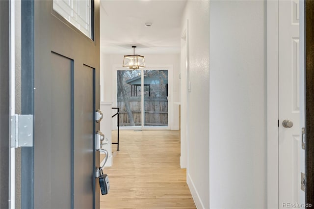 entrance foyer featuring light hardwood / wood-style flooring and a chandelier