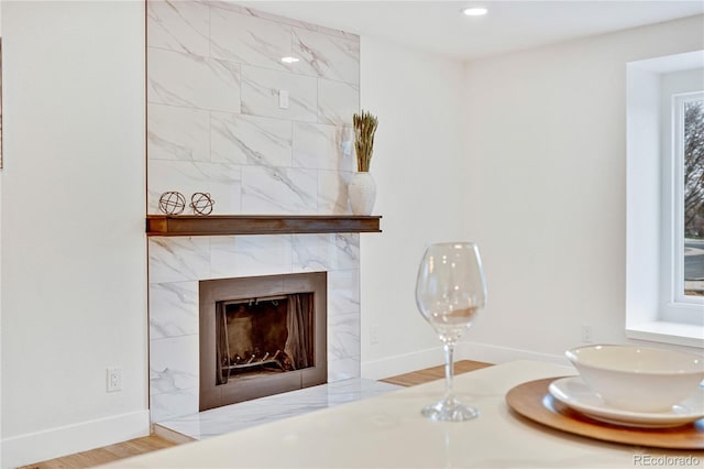 interior details with a high end fireplace and hardwood / wood-style flooring