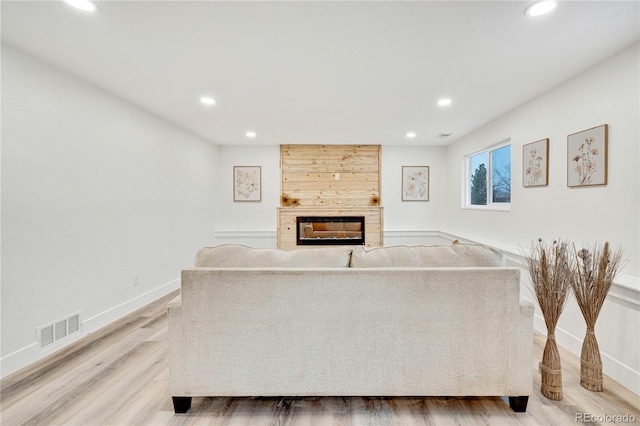 living room featuring hardwood / wood-style floors and a tiled fireplace