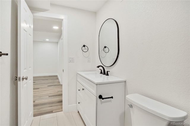 bathroom featuring hardwood / wood-style floors, vanity, and toilet