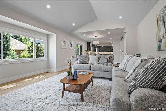 34 Honey Locust, Littleton, CO 80127 - living area featuring vaulted ceiling, healthy amount of natural light, light wood finished floors, a chandelier, and recessed lighting