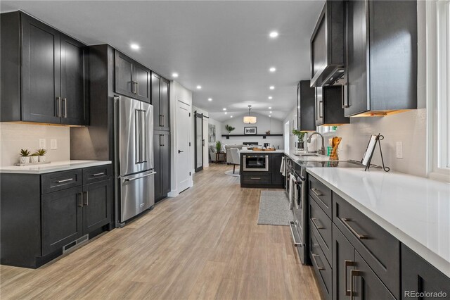 34 Honey Locust, Littleton, CO 80127 - kitchen featuring stainless steel appliances, light wood-style flooring, light countertops, recessed lighting, and dark cabinets