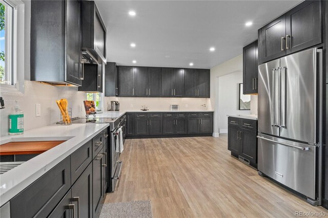 34 Honey Locust, Littleton, CO 80127 - kitchen with appliances with stainless steel finishes, light wood-type flooring, light countertops, dark cabinetry, and recessed lighting