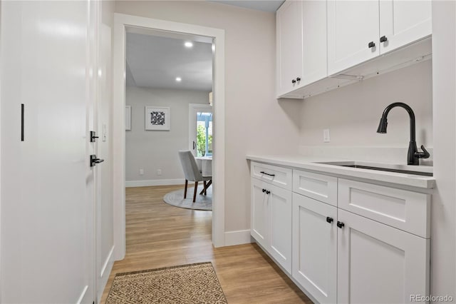 34 Honey Locust, Littleton, CO 80127 - kitchen with white cabinets, light wood-style floors, light countertops, and recessed lighting