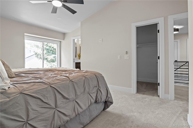 34 Honey Locust, Littleton, CO 80127 - carpeted bedroom featuring a walk in closet, vaulted ceiling, ensuite bathroom, and ceiling fan