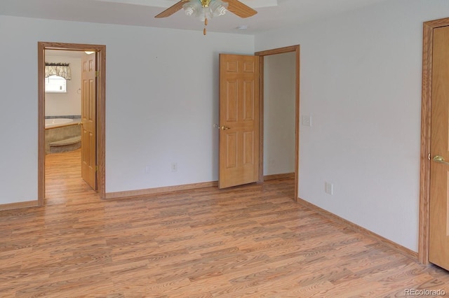 unfurnished bedroom featuring light wood-style flooring, baseboards, ensuite bath, and a ceiling fan