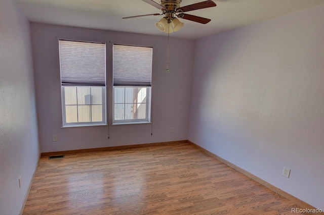 unfurnished room featuring ceiling fan, light wood-type flooring, and baseboards