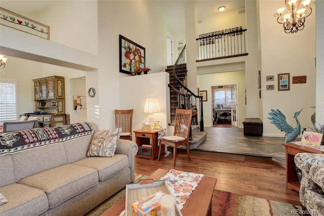 living room with plenty of natural light, a towering ceiling, and an inviting chandelier