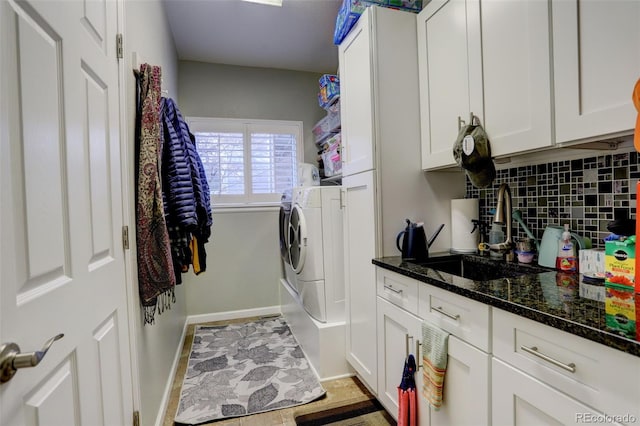 clothes washing area with cabinets, washing machine and dryer, and sink