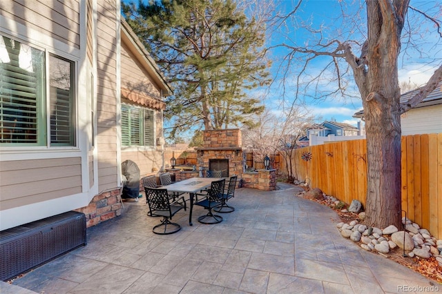 view of patio / terrace featuring an outdoor stone fireplace and radiator heating unit