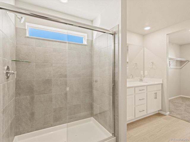 bathroom featuring a shower with door, vanity, and wood-type flooring