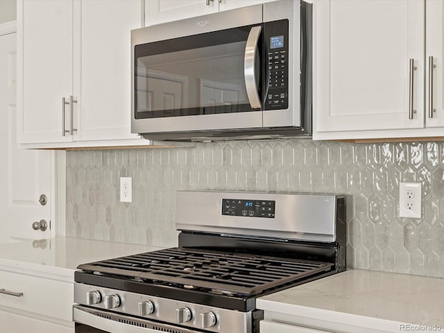 kitchen featuring white cabinetry, backsplash, and appliances with stainless steel finishes