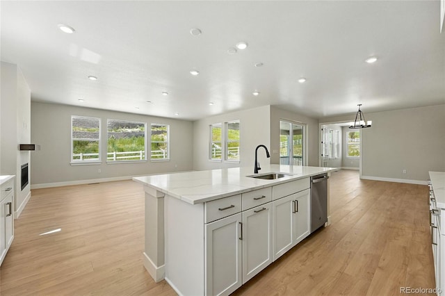 1672 Fox Trotter Pt, Castle Rock, CO 80104 - kitchen with open floor plan, light wood-style floors, a center island with sink, recessed lighting, and stainless steel dishwasher