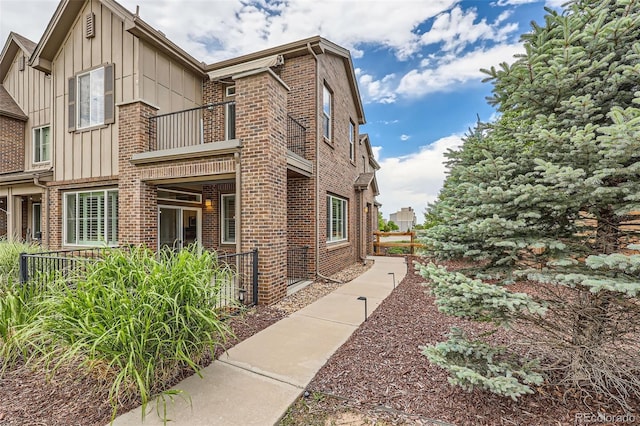 606 E Dry Creek Pl, Littleton, CO 80122 - view of property exterior with a balcony, brick siding, and board and batten siding