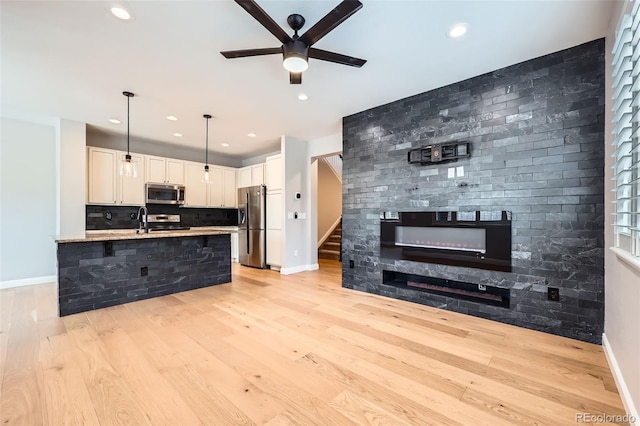 606 E Dry Creek Pl, Littleton, CO 80122 - kitchen with stainless steel appliances, ceiling fan, light wood-style floors, hanging light fixtures, and recessed lighting