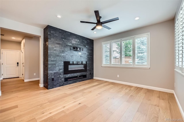 606 E Dry Creek Pl, Littleton, CO 80122 - unfurnished living room featuring a large fireplace, ceiling fan, healthy amount of natural light, light wood-type flooring, and recessed lighting