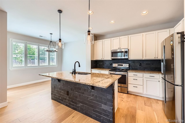 606 E Dry Creek Pl, Littleton, CO 80122 - kitchen featuring appliances with stainless steel finishes, light stone countertops, backsplash, light wood-style floors, and recessed lighting