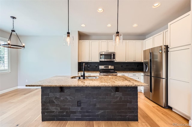 606 E Dry Creek Pl, Littleton, CO 80122 - kitchen with stainless steel appliances, tasteful backsplash, light stone countertops, light wood-style floors, and white cabinets