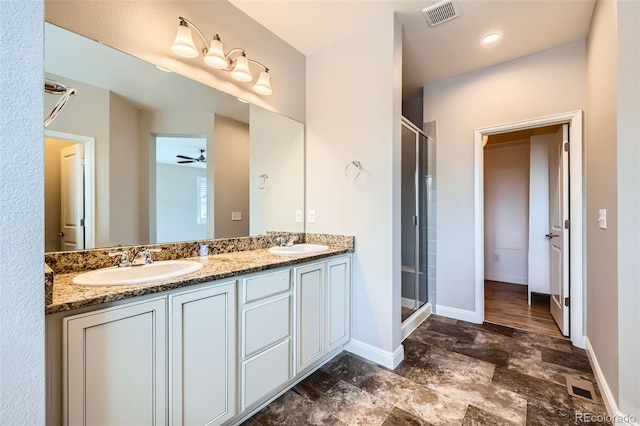 606 E Dry Creek Pl, Littleton, CO 80122 - full bathroom featuring a shower stall, double vanity, stone finish floors, and ceiling fan