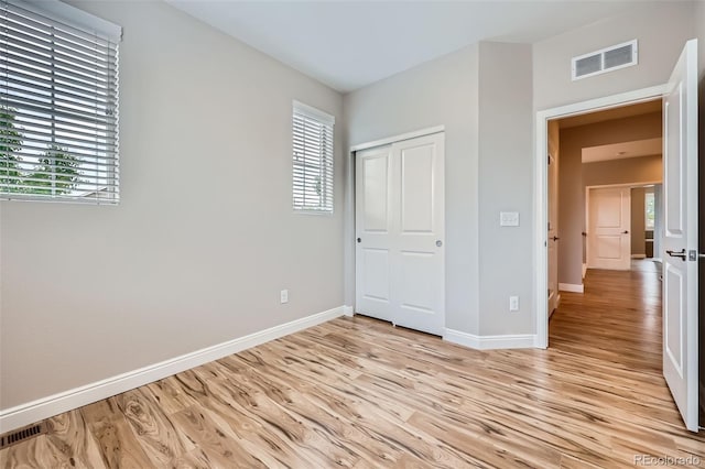 606 E Dry Creek Pl, Littleton, CO 80122 - unfurnished bedroom with light wood-type flooring, multiple windows, and a closet
