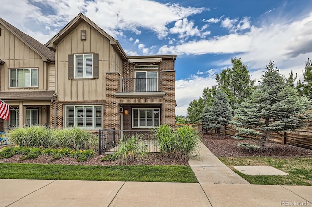 606 E Dry Creek Pl, Littleton, CO 80122 - view of front facade featuring a balcony, brick siding, and board and batten siding