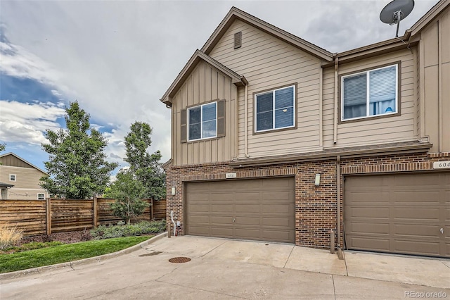606 E Dry Creek Pl, Littleton, CO 80122 - townhome / multi-family property with a garage, brick siding, board and batten siding, and driveway