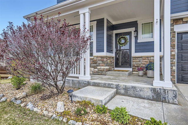 entrance to property with covered porch and stone siding
