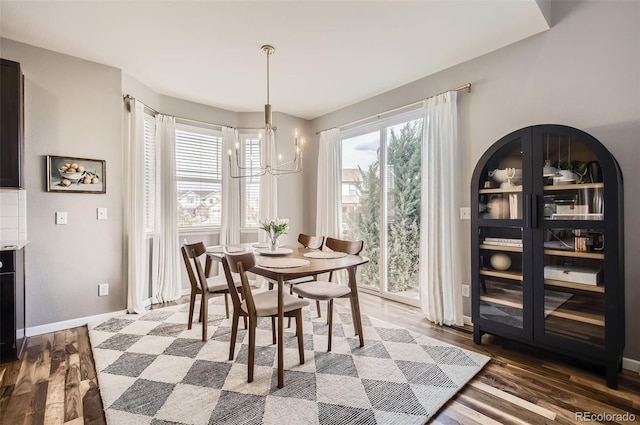 dining room featuring baseboards, wood finished floors, and a chandelier
