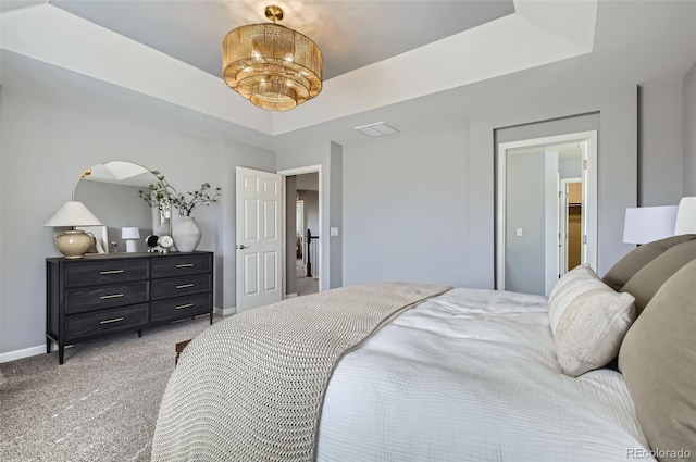 bedroom with baseboards, light carpet, a tray ceiling, and visible vents