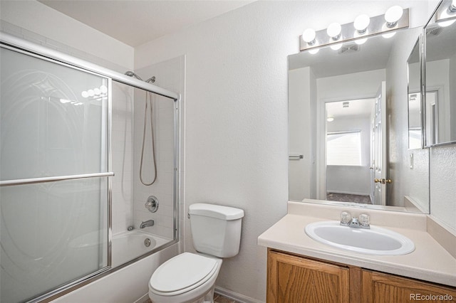 full bathroom with vanity, toilet, and combined bath / shower with glass door