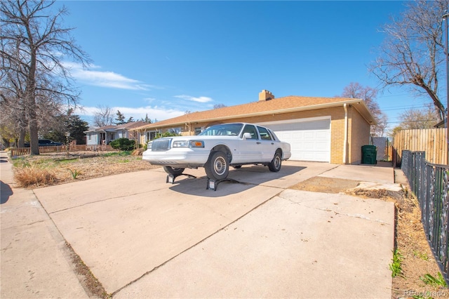 view of front of home featuring a garage, a chimney, fence, concrete driveway, and brick siding