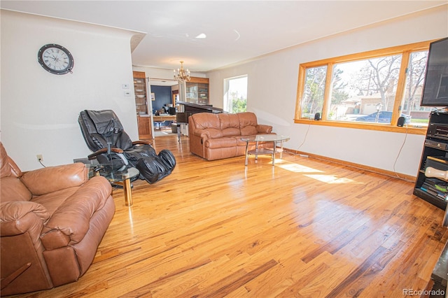 living area featuring baseboards, a chandelier, and wood finished floors