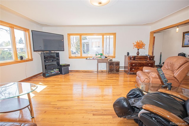 living room with baseboards, a healthy amount of sunlight, and light wood-style flooring