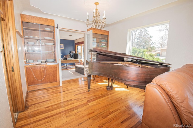 living area featuring light wood finished floors and a chandelier