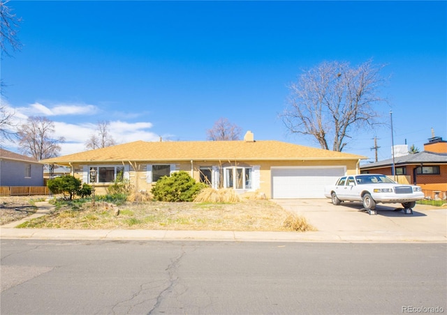 single story home featuring an attached garage, concrete driveway, and a chimney