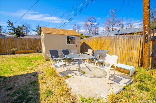 view of patio featuring a fenced backyard, a storage shed, and an outbuilding