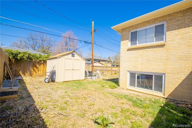 view of yard with a storage shed, an outdoor structure, and a fenced backyard